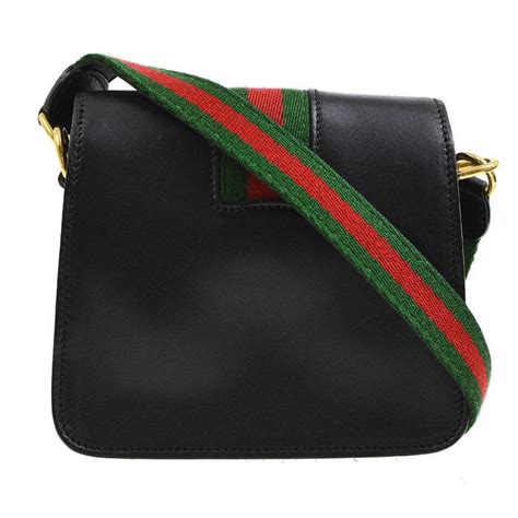 gucci crossbody with striped strap.